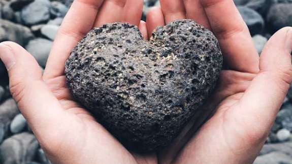 image of hands holding a stone heart