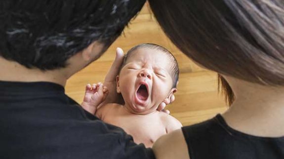 Image of parents looking at a  baby