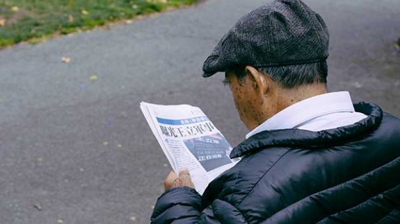 Image of a man reading a newspaper